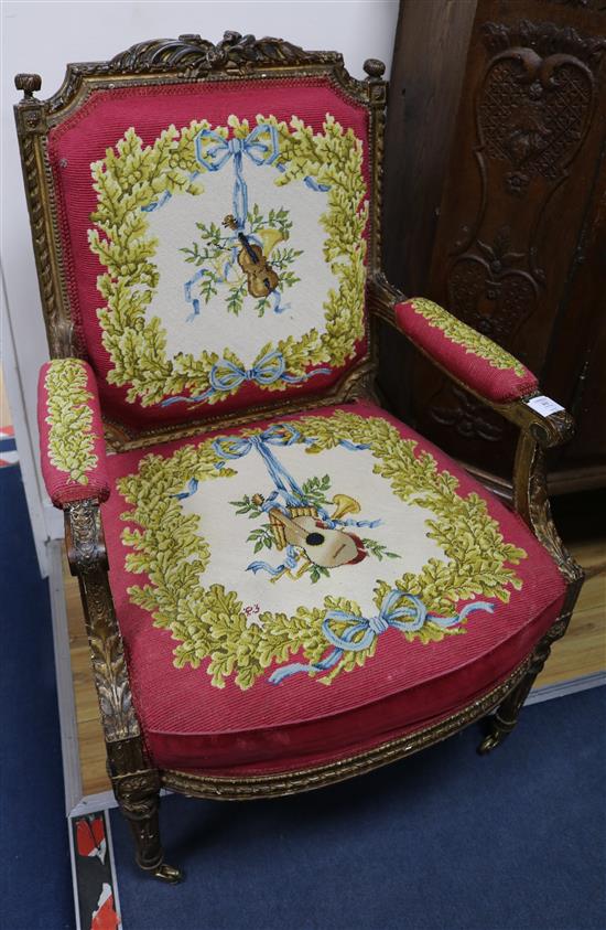A late 19th century Louis XVI style carved parcel gilt fauteuil